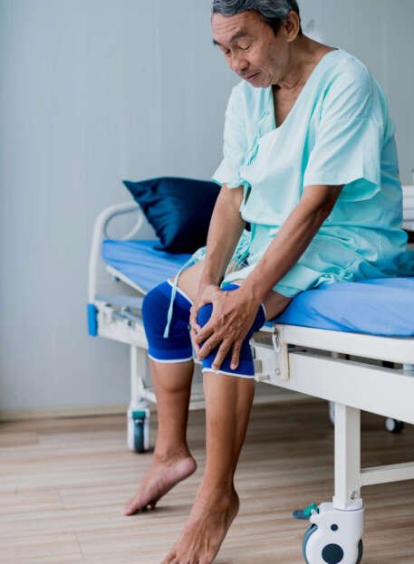 old asian senior man complains about all the aches and pains he has at his age meet doctor in hospital
